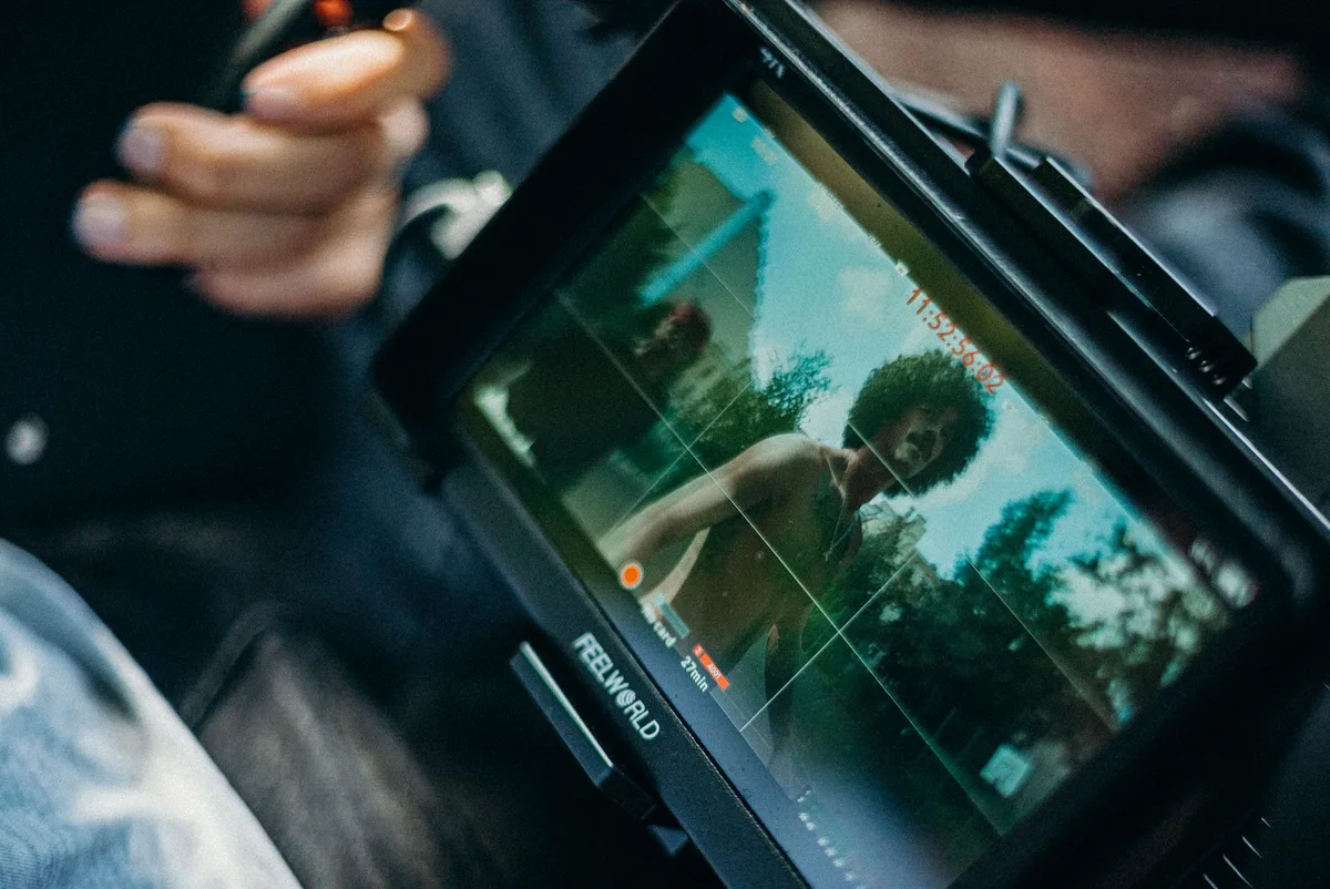 Independent creators and filmmakers networking at a film festival premiere event with professional lighting and screens.
