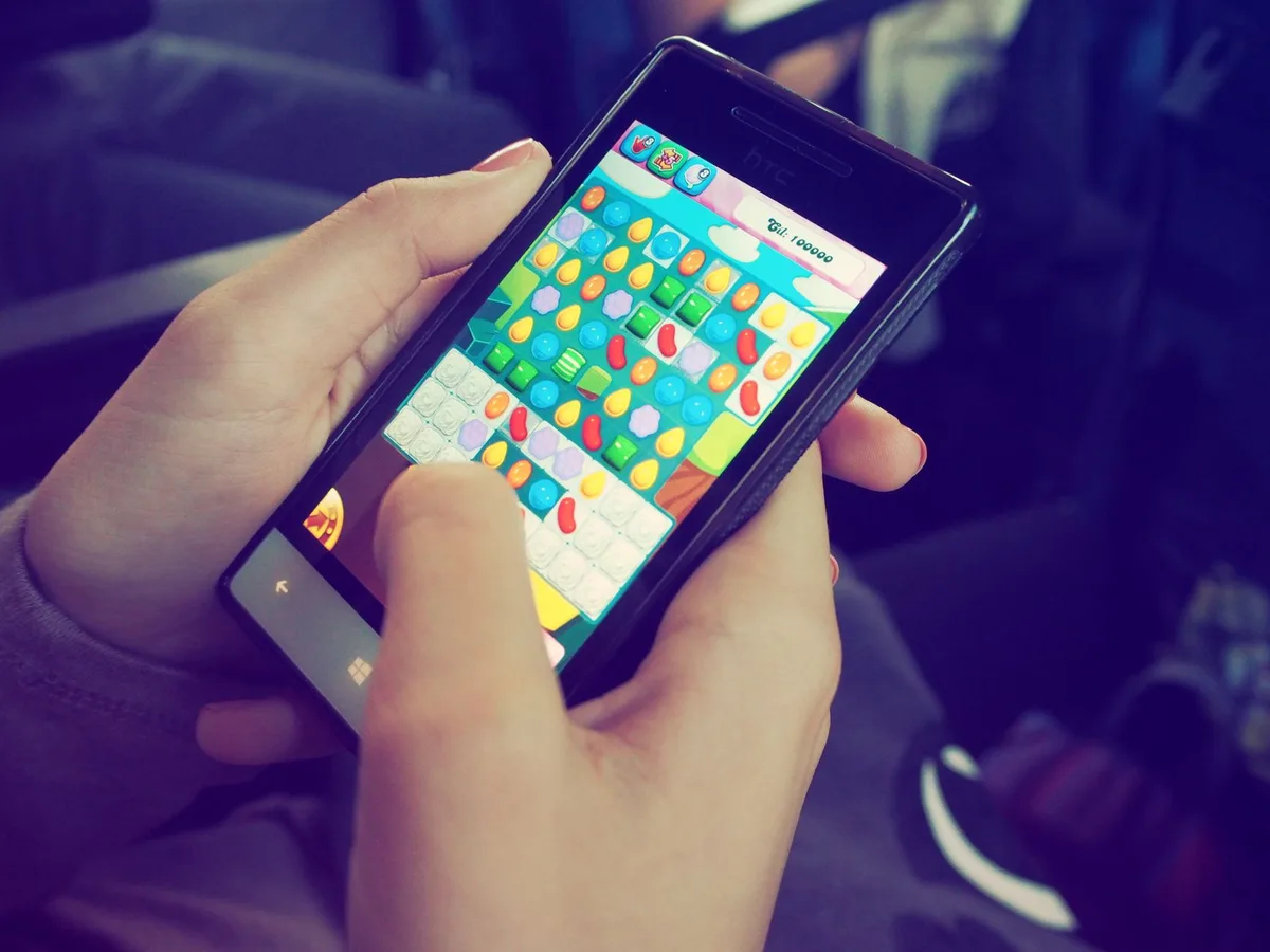 Ein Smartphone zeigt eine Gaming-App mit einer Belohnungsbenachrichtigung und Kontoverknüpfungsoptionen.