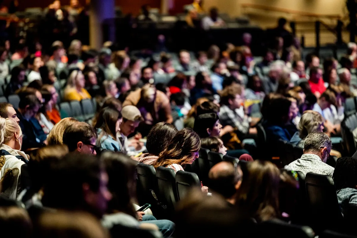 Crowd of gaming fans watching a live gaming showcase on screens