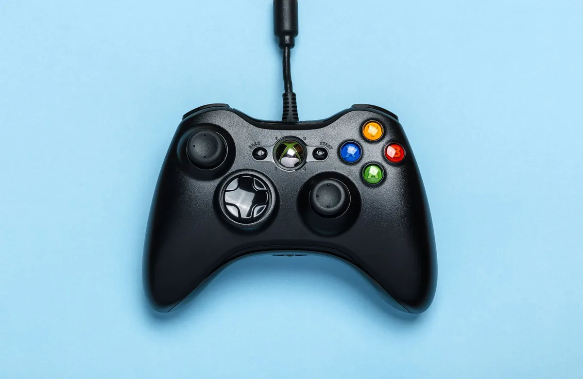 Compact folded gamepad with extendable side grips mounted to smartphone via magnetic attachment on desk