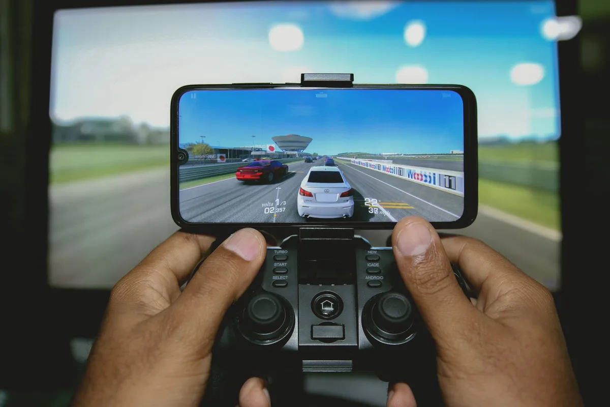 Gamer holding a mobile controller with swept-back grips during extended gaming session