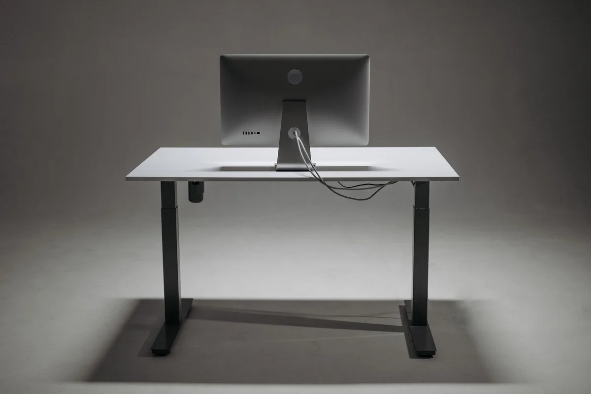 Sleek gaming monitor with adjustable stand and compact base on a gaming desk