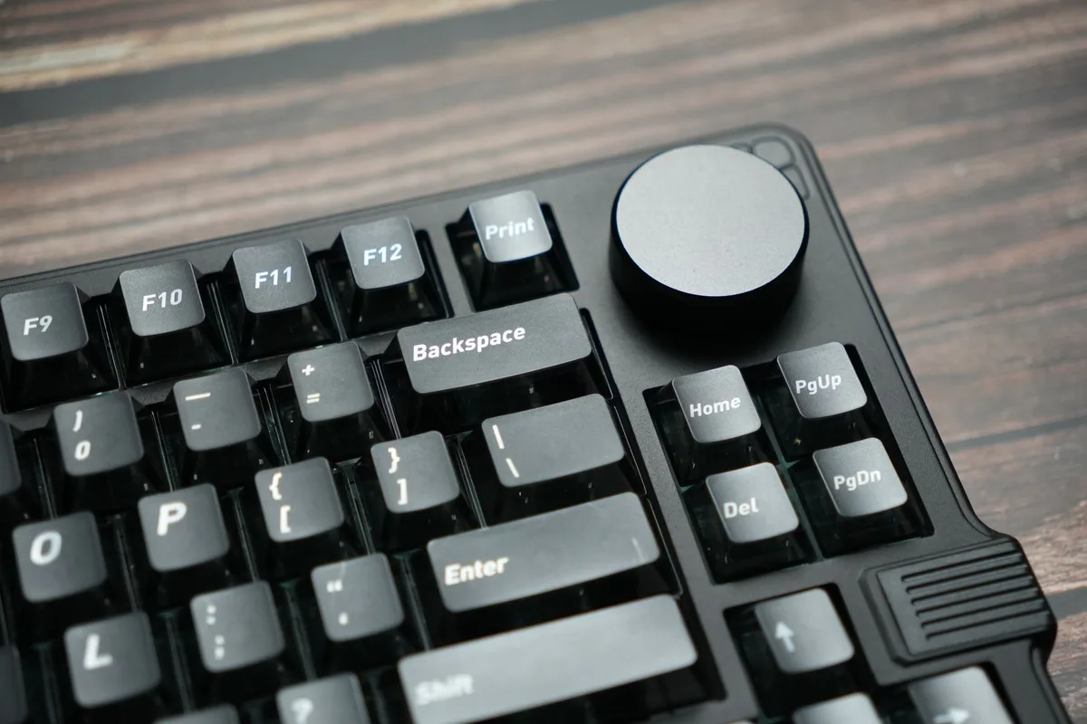 Close-up of hands typing on a mechanical gaming keyboard with illuminated keys.