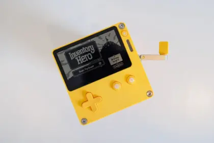 Yellow gaming controller on a desk with online retailer tabs in background