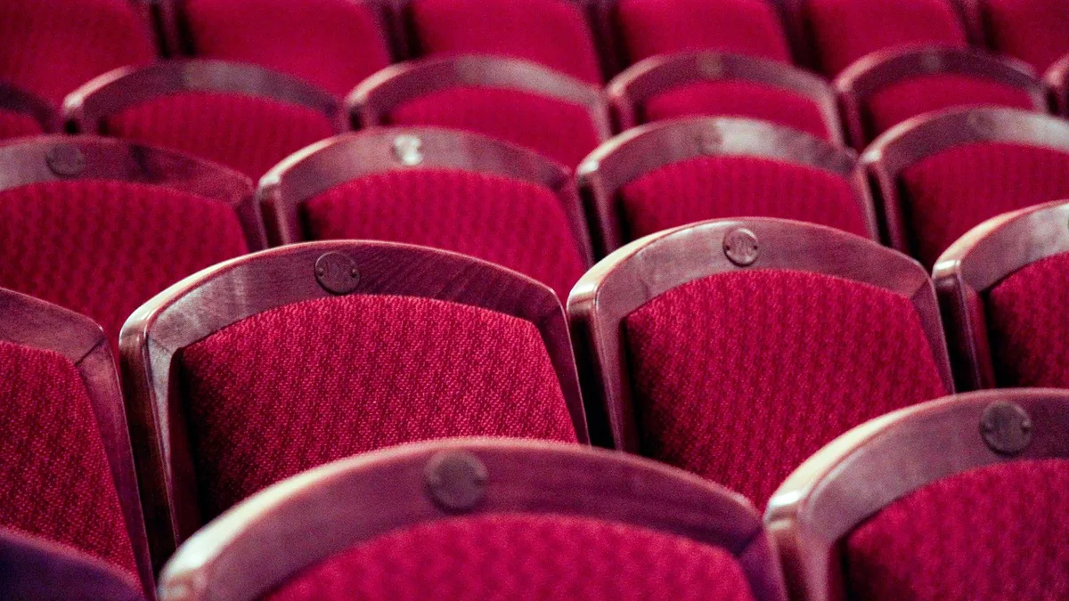 Audience reaction in a dim movie theater during a horror screening