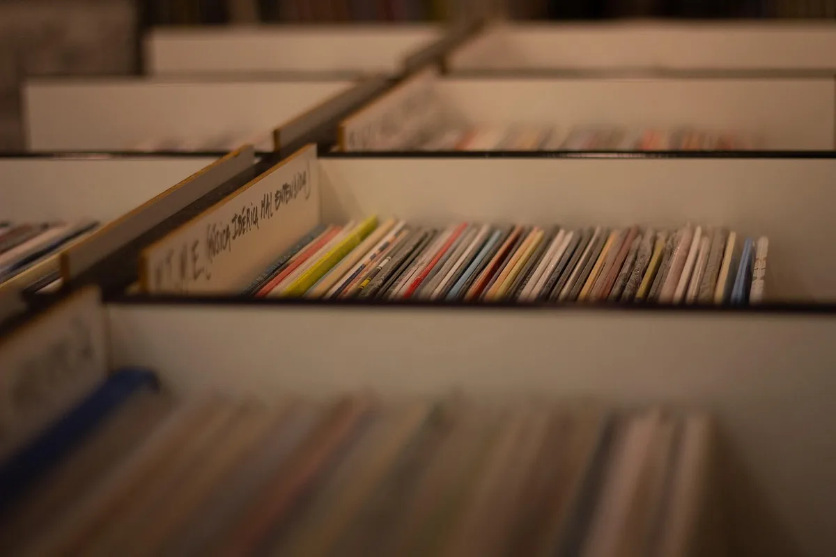 Vinyl records and modern headphones representing different ways to listen to The Beatles