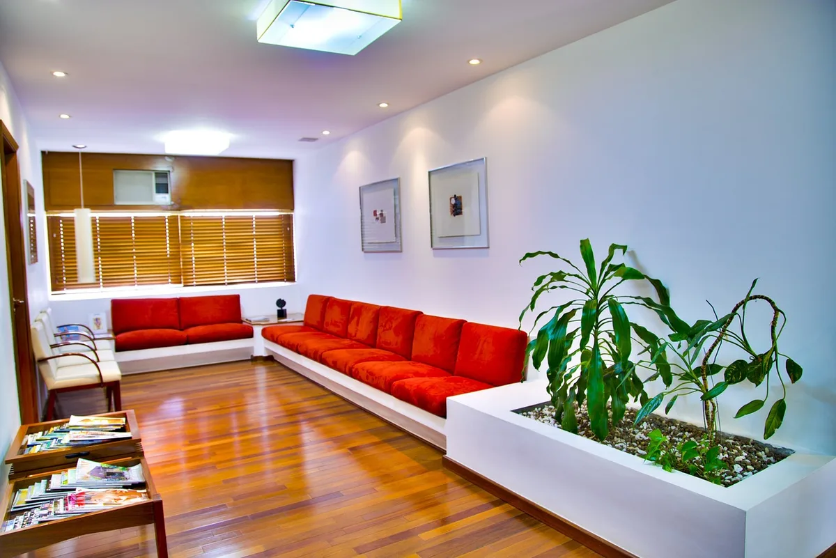 Daylit living room with closed door and a hand reaching for the knob