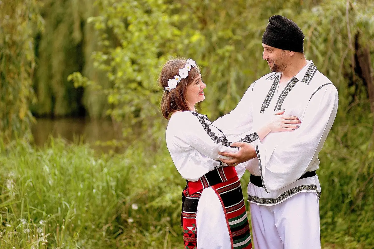 Actors in period costume outside a Highland cottage discussing family matters