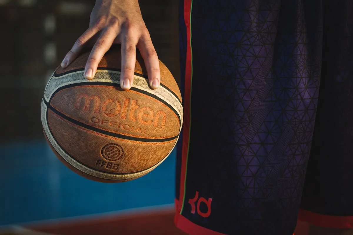 Hands holding a handheld showing rubberized grips and buttons