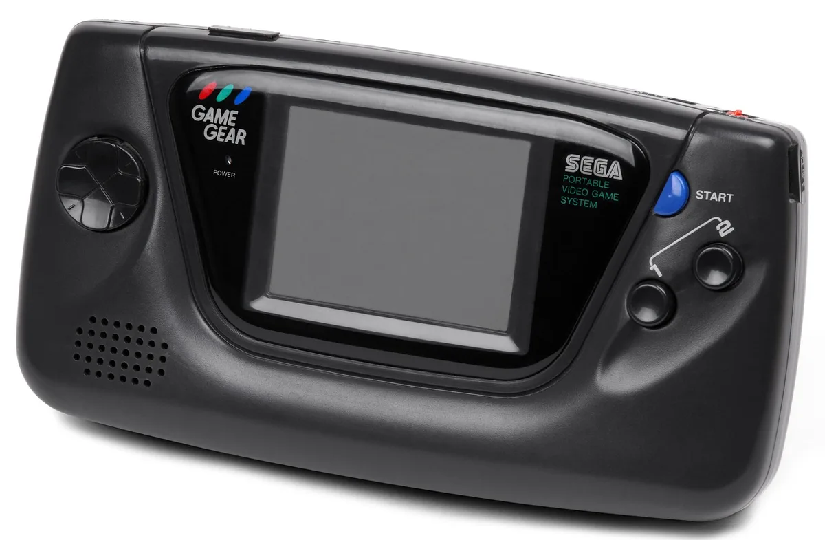 Hands inserting a game cartridge into a handheld console on a bright tabletop