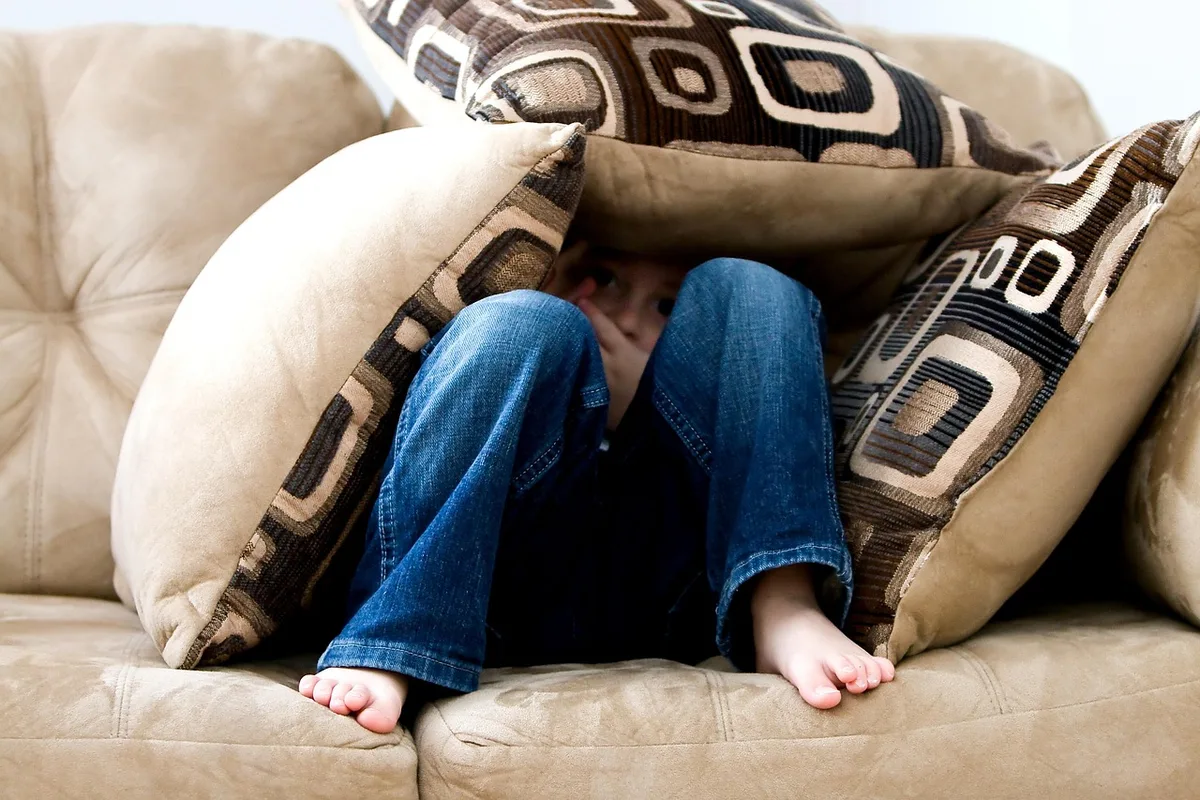 Player on a sofa holding a Switch controller in a bright room