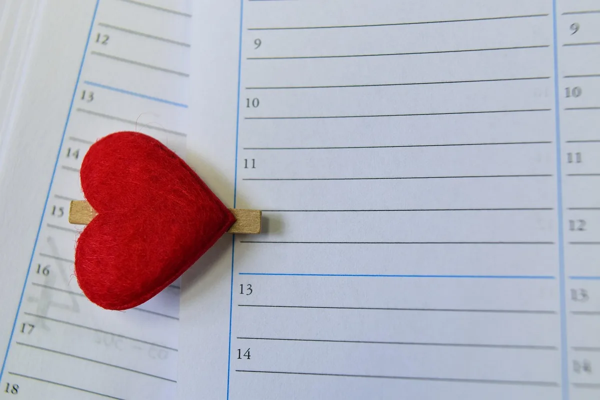 Calendar with weekly episode dates marked in daylight on a table