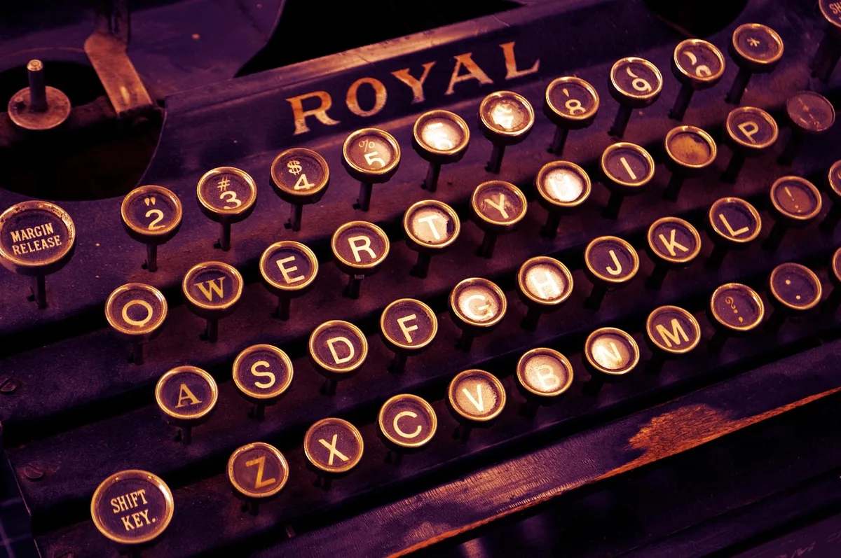 Hands hovering over a printed word puzzle on a bright desk